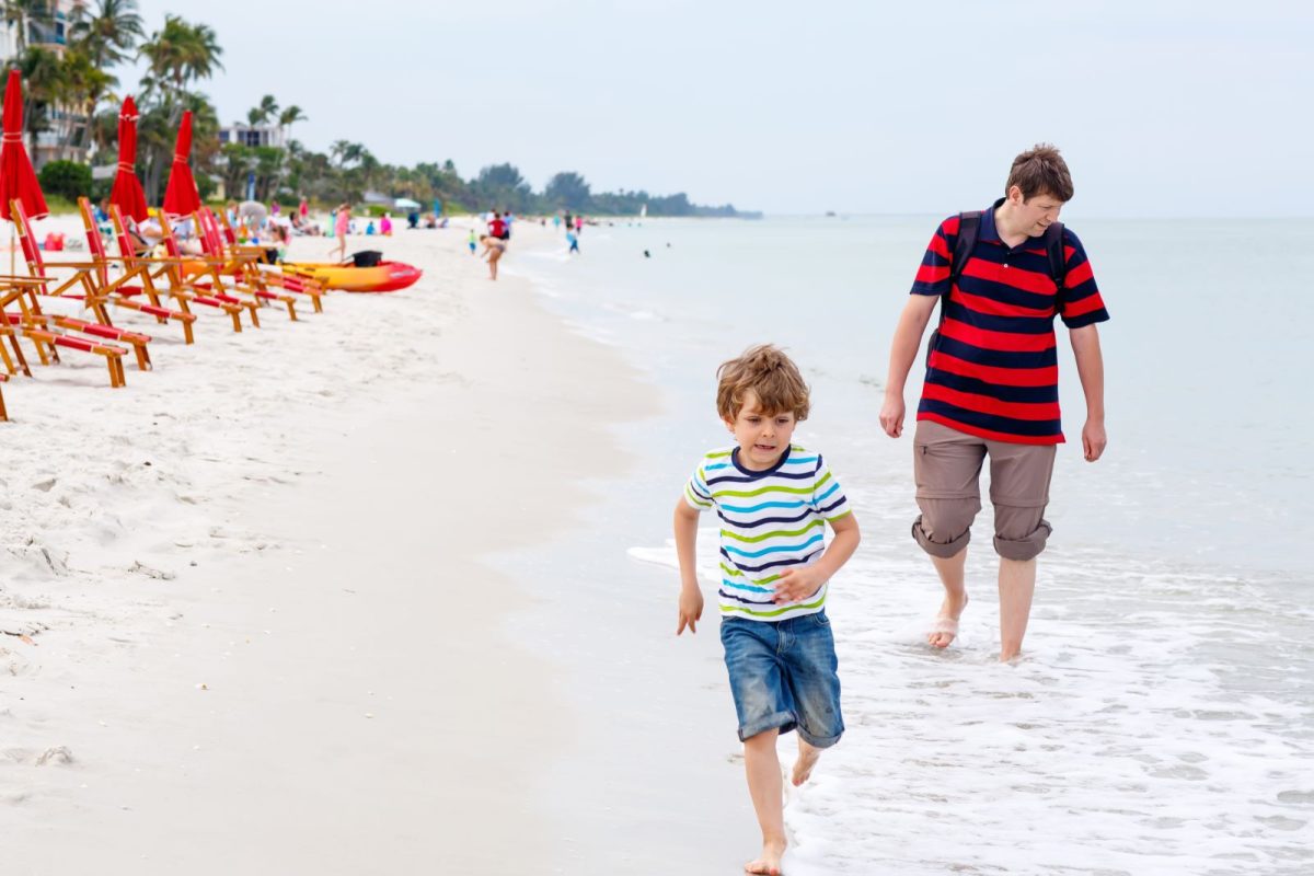 father and son walking on beach